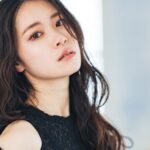 黒いレースのトップスを着て振り返る長い髪の女性