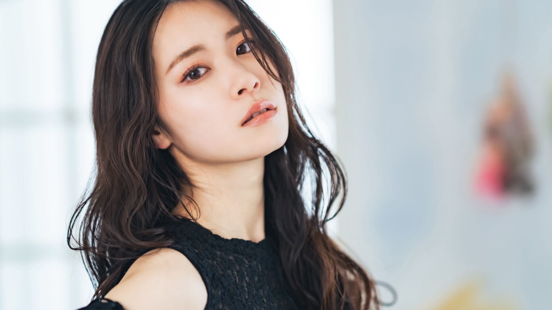 黒いレースのトップスを着て振り返る長い髪の女性