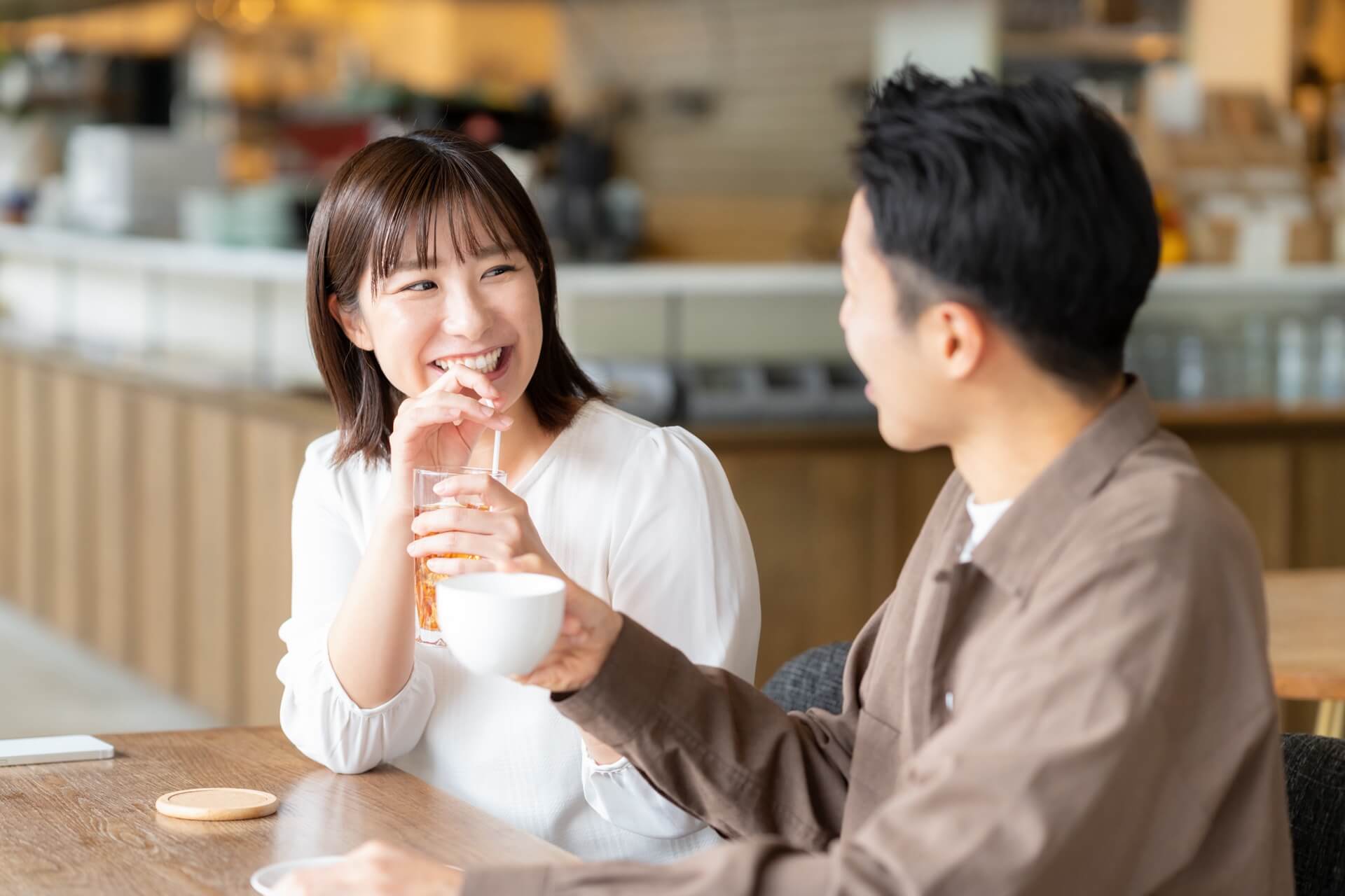 カフェで向かい合って会話を楽しむ男女