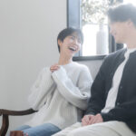 窓辺の明るい部屋で楽しそうに笑い合う男女