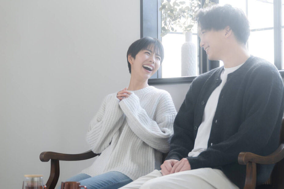 窓辺の明るい部屋で楽しそうに笑い合う男女