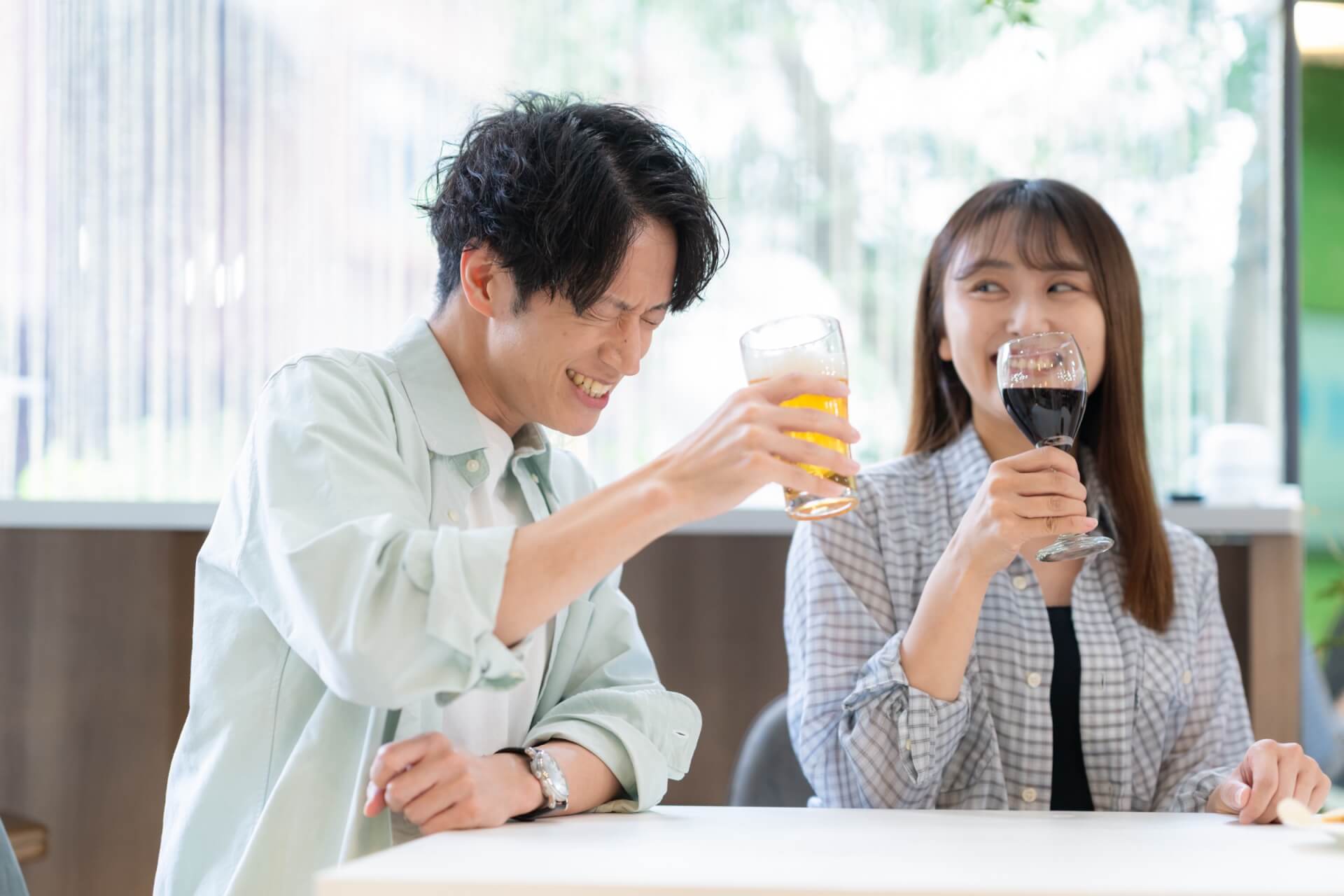 飲み物を手に乾杯して会話を楽しむ男女