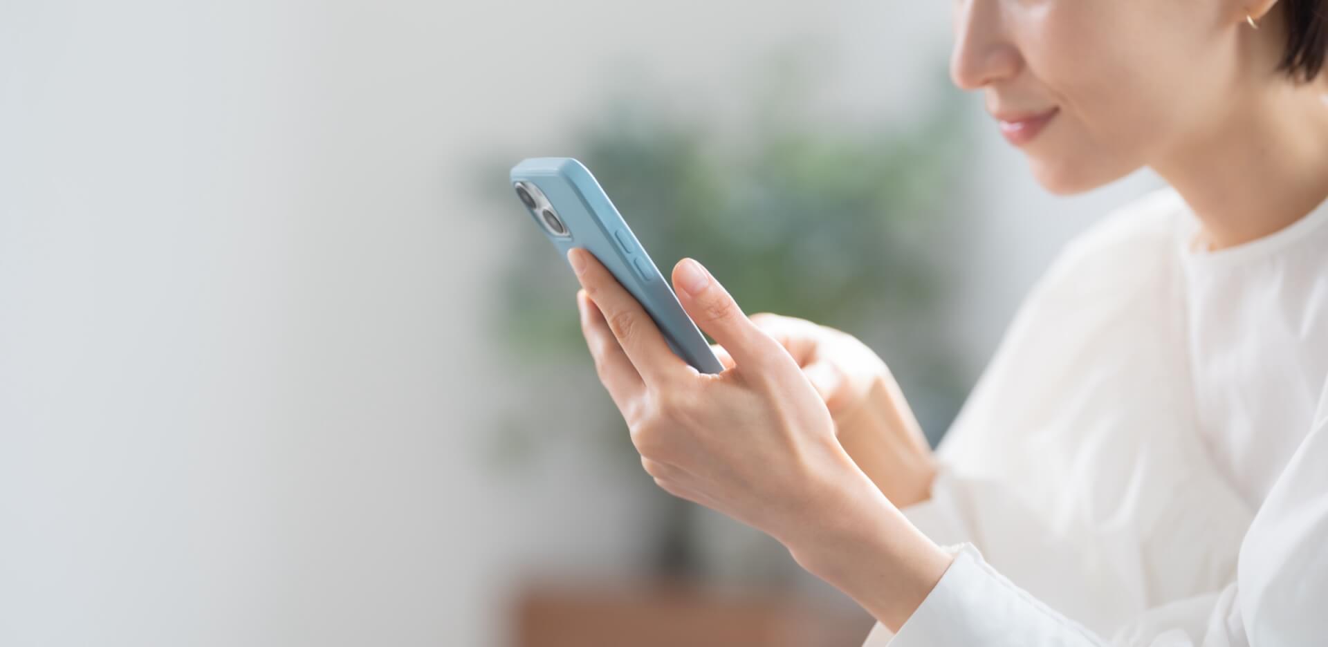 スマートフォンの画面を操作する女性の手元