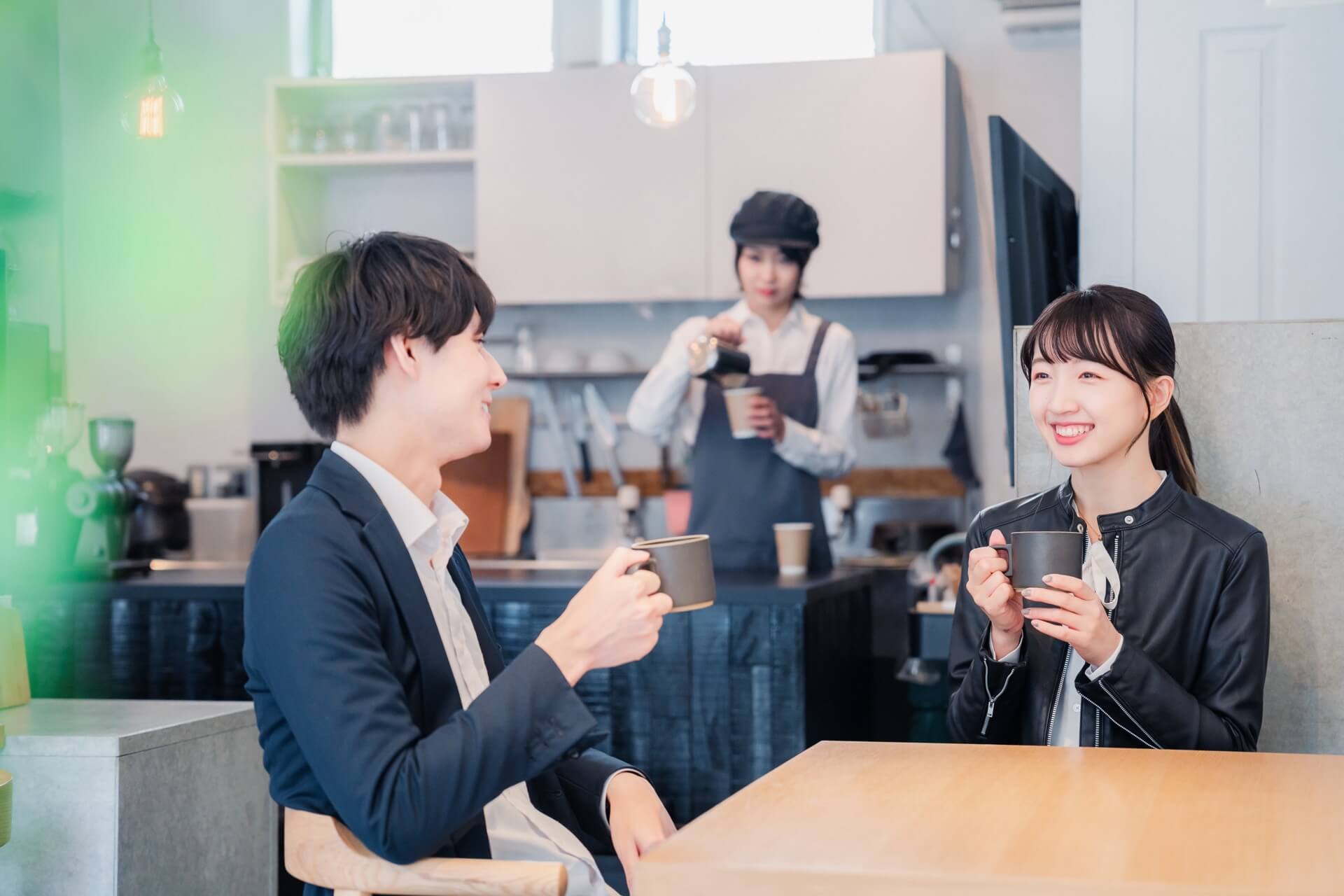カフェで向かい合って会話をする初デートの男女