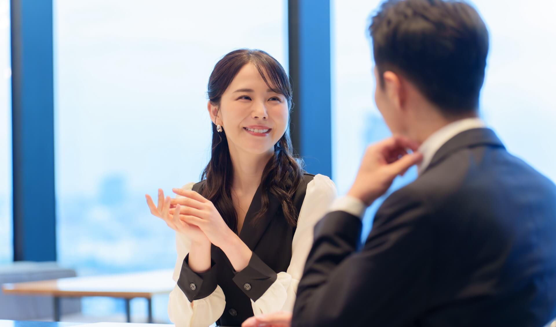 窓辺のレストランで向かい合って会話する男女