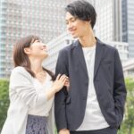 オフィス街で寄り添って笑顔を交わすジャケット姿の男性と女性