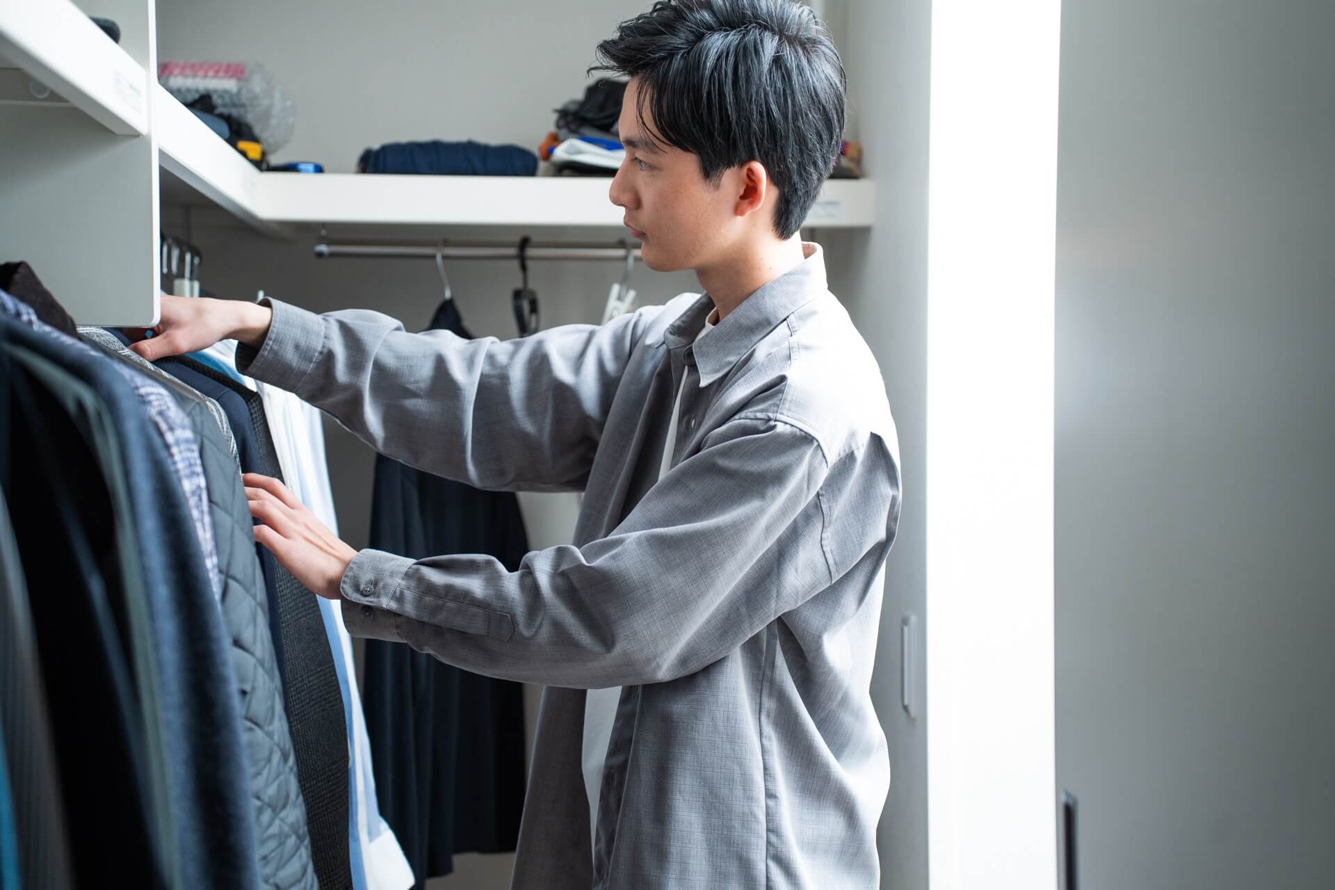 クローゼットの前で初デートに着ていく服を選ぶ男性