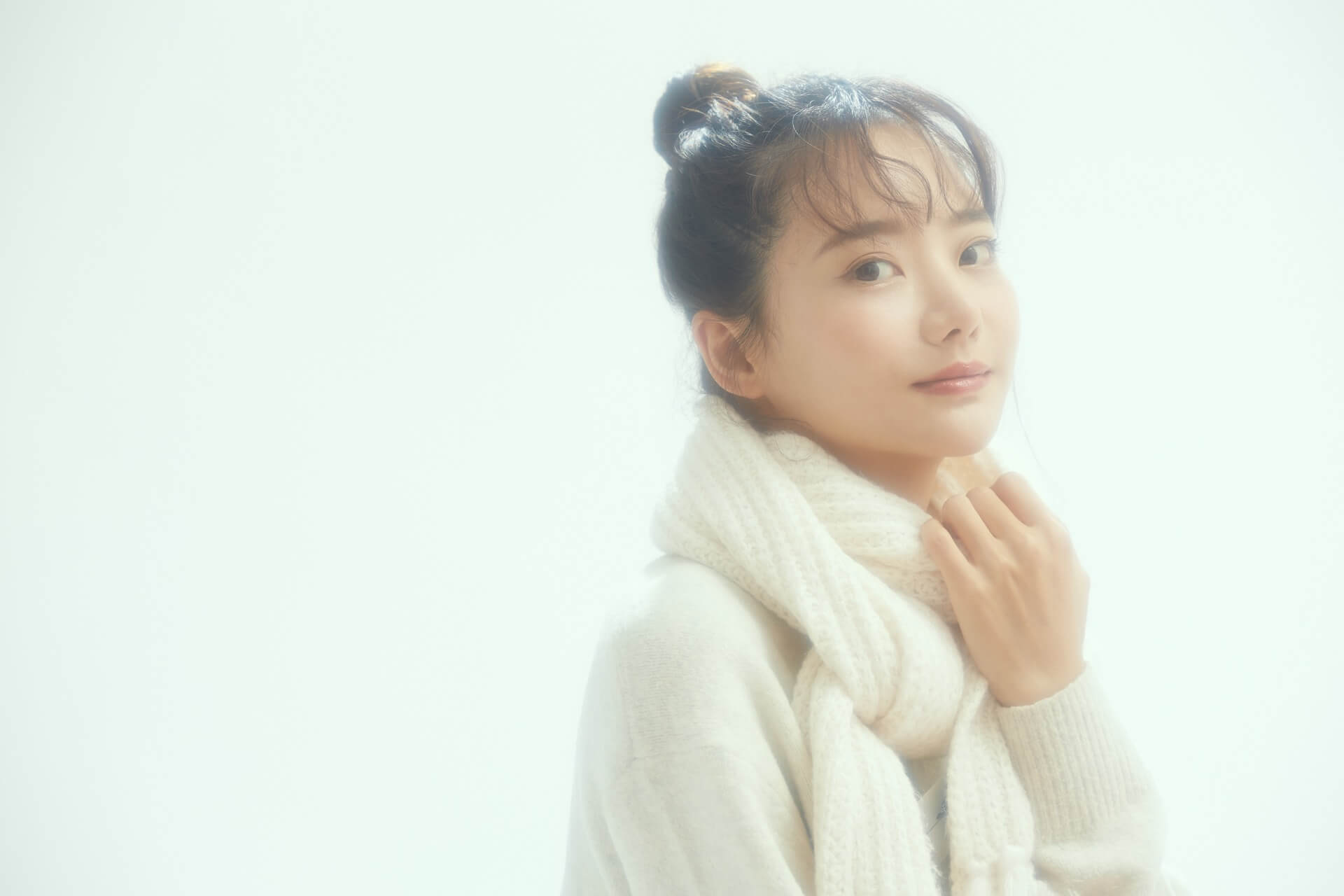 アイボリーのマフラーを巻いた、やわらかい雰囲気の女性